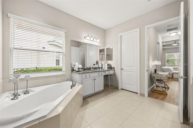 bathroom with vanity, a garden tub, visible vents, and tile patterned floors