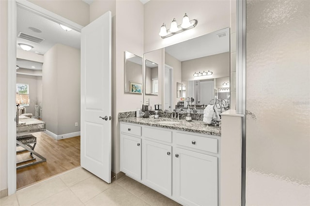 full bath with baseboards, vanity, visible vents, and tile patterned floors