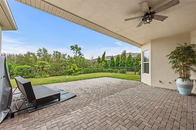 view of patio / terrace with fence and a ceiling fan