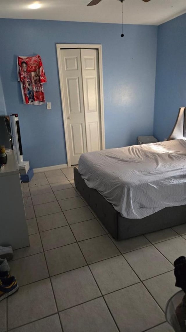 bedroom featuring ceiling fan, a closet, and tile patterned floors