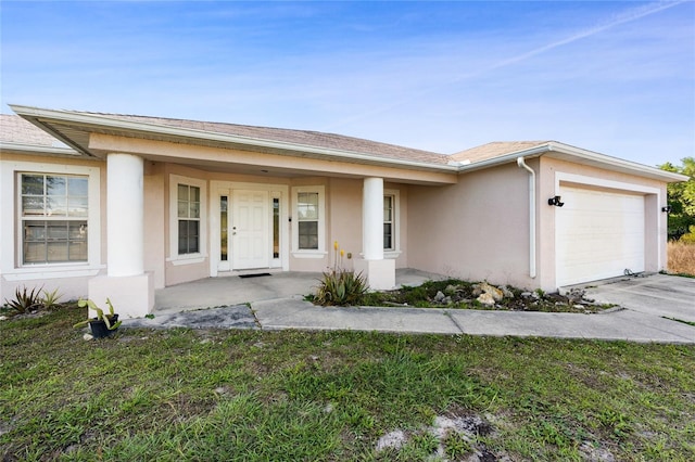 915 Poinsettia Ave, Lehigh Acres, FL 33972 - view of front facade featuring a garage, a front yard, a porch, and stucco siding