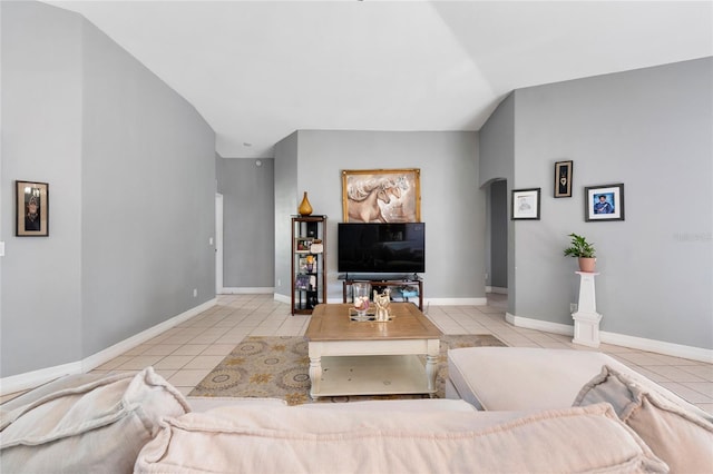 915 Poinsettia Ave, Lehigh Acres, FL 33972 - tiled living room with baseboards, arched walkways, and vaulted ceiling