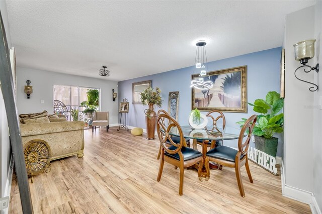 dining area featuring a textured ceiling and light wood-type flooring