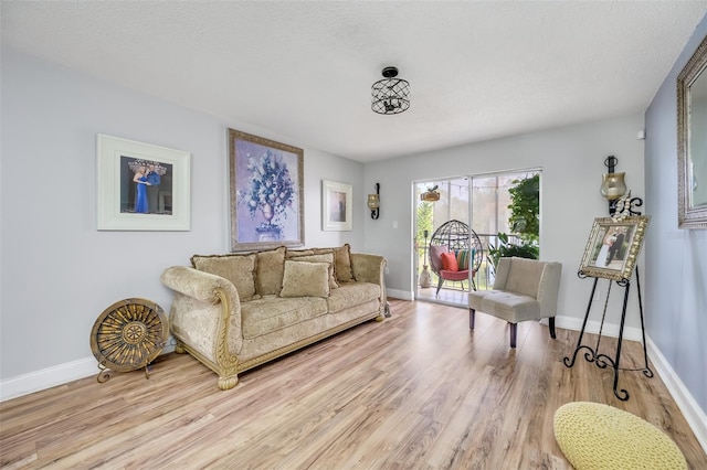 living room with a textured ceiling and light wood-type flooring