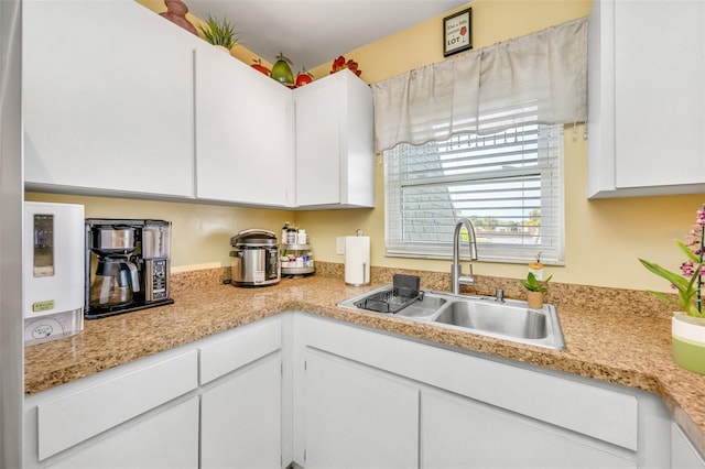 kitchen featuring white cabinetry and sink