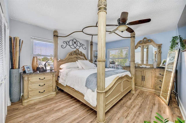 bedroom featuring ceiling fan, light hardwood / wood-style floors, and a textured ceiling