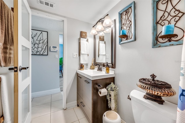 bathroom featuring toilet, tile patterned floors, and vanity