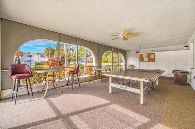 rec room with a textured ceiling, ceiling fan, and carpet flooring