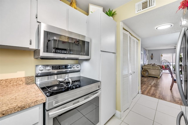 kitchen featuring white cabinetry, light tile patterned floors, and stainless steel appliances