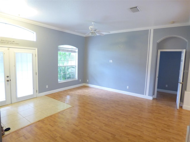 spare room featuring ceiling fan, light hardwood / wood-style floors, crown molding, and french doors