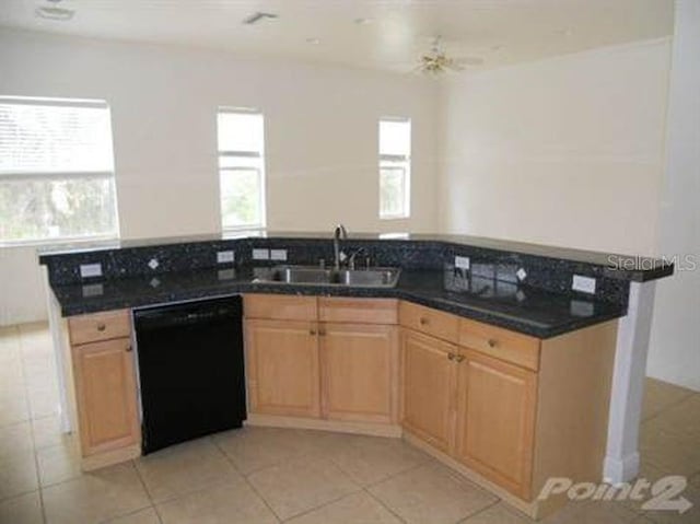 kitchen featuring plenty of natural light, sink, black dishwasher, and light tile patterned flooring