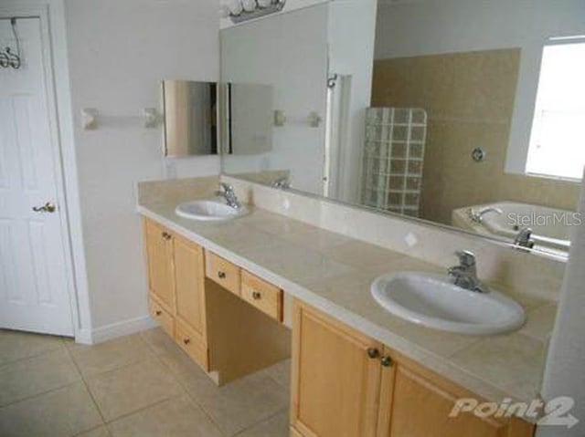 bathroom featuring vanity, tile patterned floors, and a tub