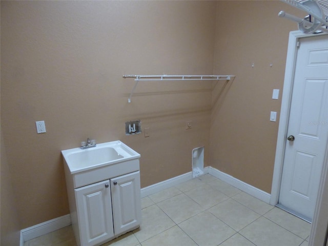 clothes washing area featuring light tile patterned floors, hookup for an electric dryer, hookup for a washing machine, cabinets, and sink