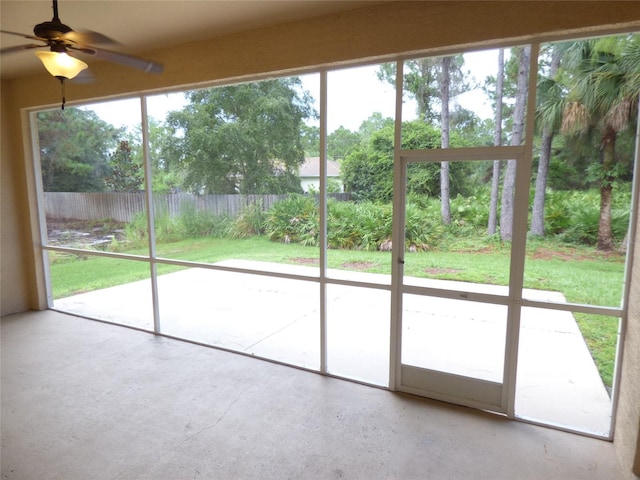 unfurnished sunroom featuring ceiling fan