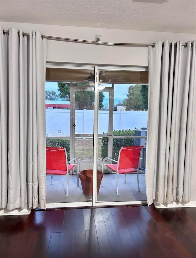 doorway to outside featuring wood-type flooring and a textured ceiling