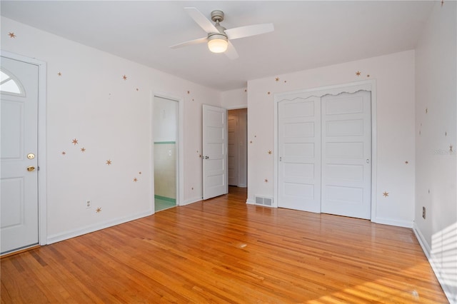 unfurnished bedroom featuring ceiling fan, a closet, and light wood-type flooring