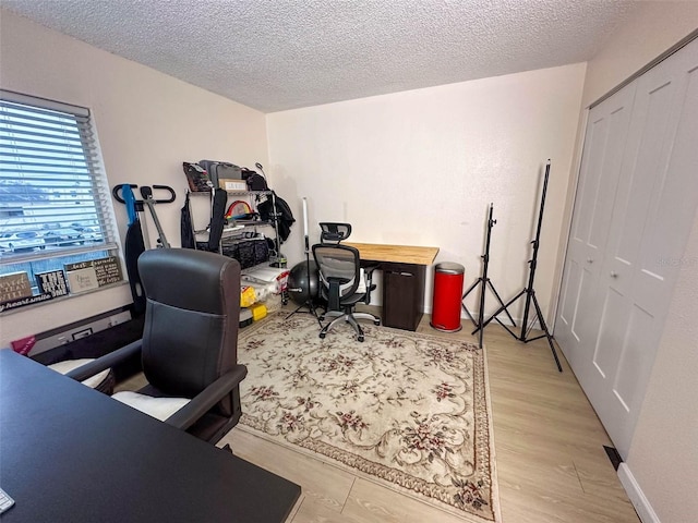 office space featuring a textured ceiling and light hardwood / wood-style flooring