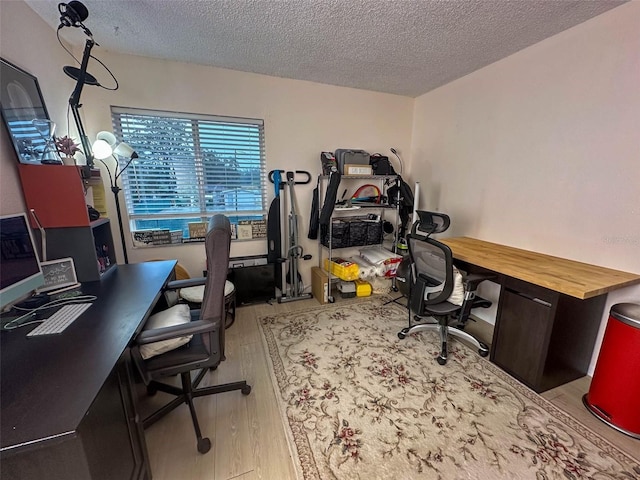 office space with a textured ceiling and light hardwood / wood-style flooring