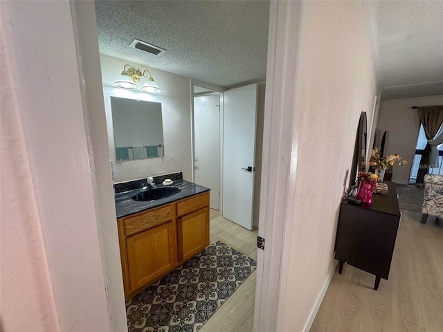 bathroom featuring hardwood / wood-style flooring, a textured ceiling, and vanity