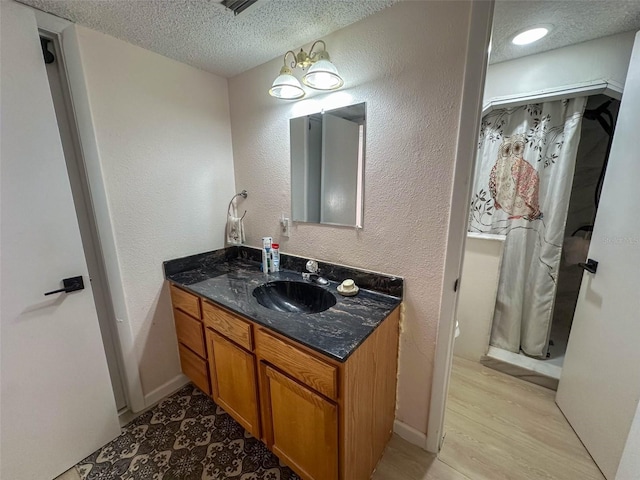 bathroom with vanity, a notable chandelier, and a textured ceiling