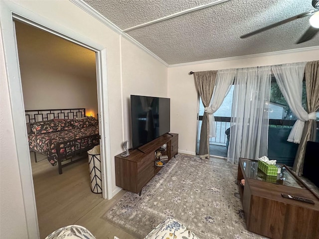 living room with ceiling fan, crown molding, a textured ceiling, and hardwood / wood-style flooring