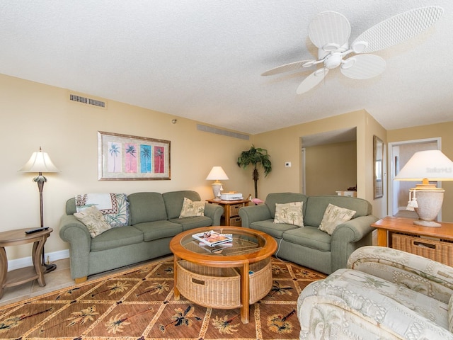 living room featuring ceiling fan, tile patterned floors, and a textured ceiling