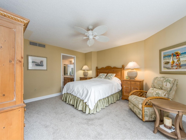 carpeted bedroom with ceiling fan, connected bathroom, and a textured ceiling