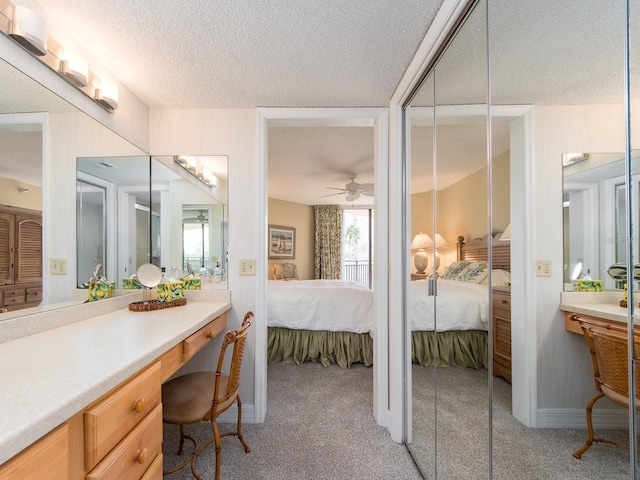 bathroom with vanity, ceiling fan, and a textured ceiling