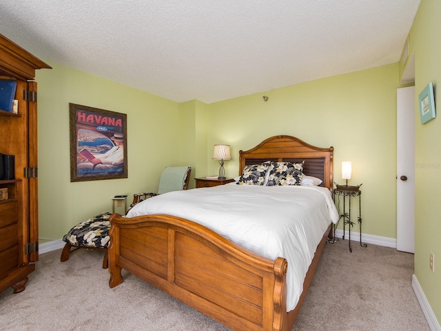 bedroom featuring light colored carpet and a textured ceiling