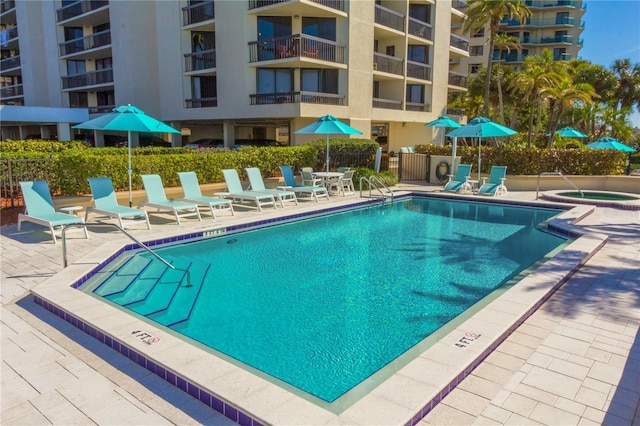 view of pool featuring a hot tub and a patio