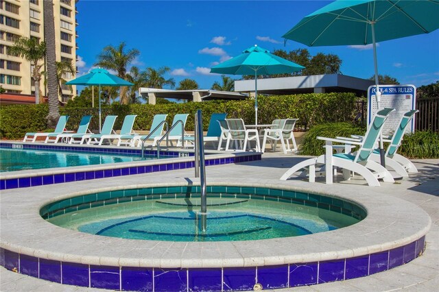 view of pool featuring a hot tub and a patio