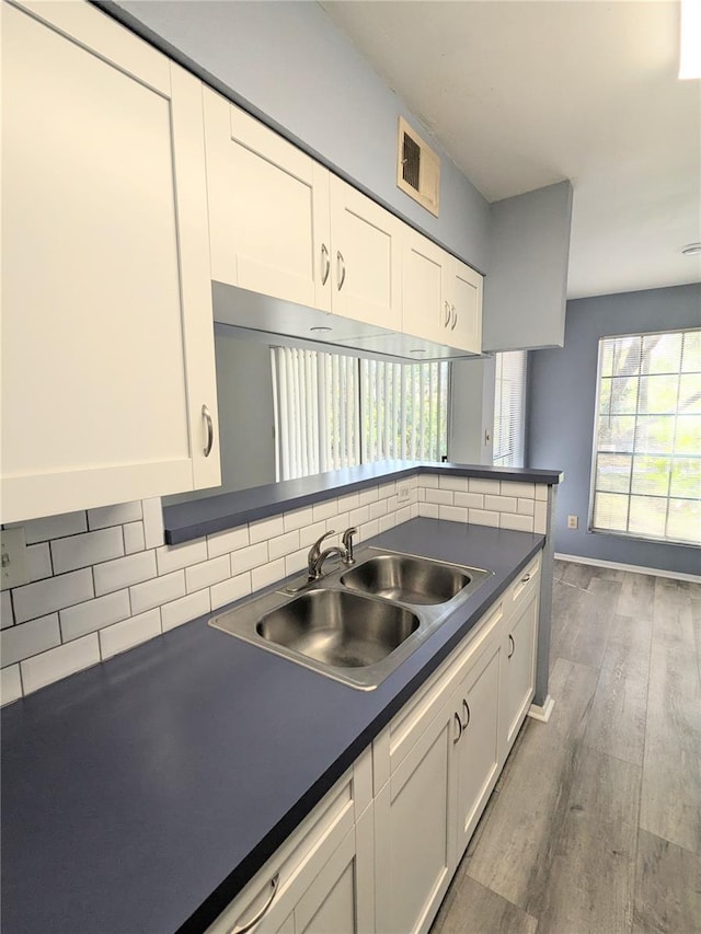 kitchen with backsplash, dark wood-type flooring, sink, and white cabinetry