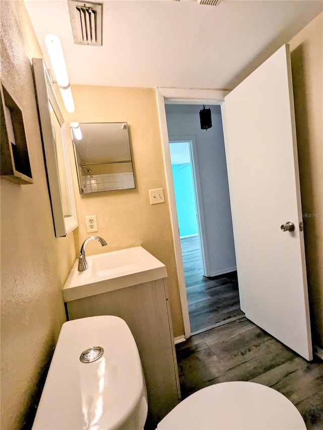 bathroom featuring hardwood / wood-style flooring, toilet, and vanity