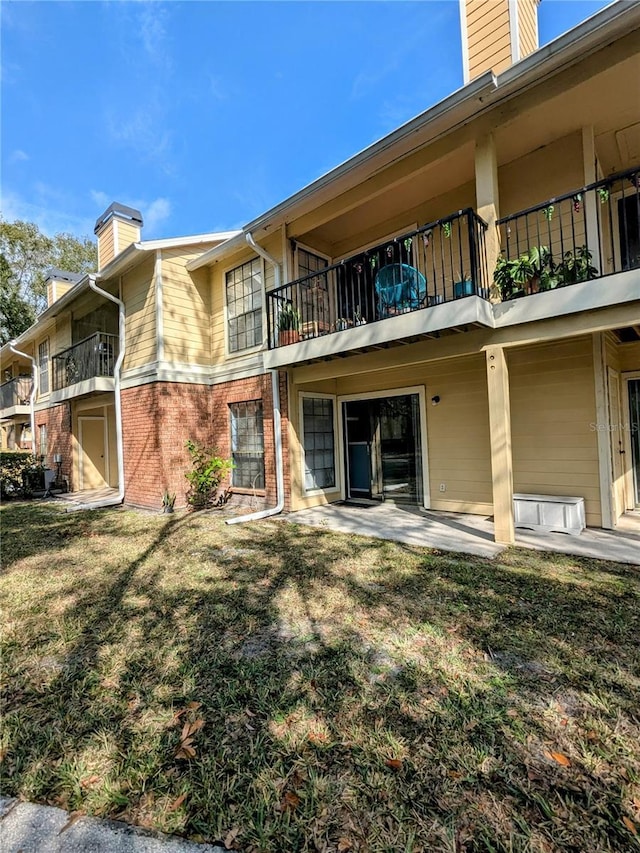 back of house featuring a lawn and a patio