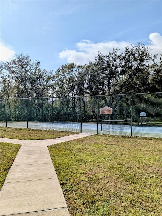 view of basketball court with tennis court and a yard