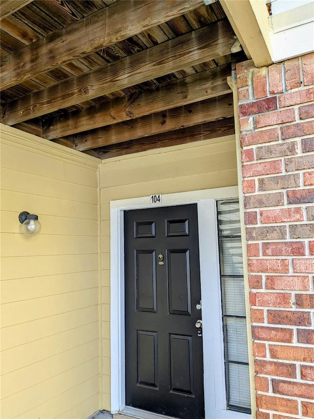 doorway to property featuring brick siding