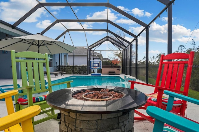 view of swimming pool with a fire pit, glass enclosure, a patio area, a hot tub, and pool water feature