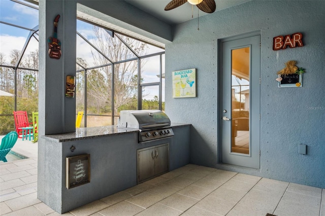 view of patio with a grill, glass enclosure, and exterior kitchen