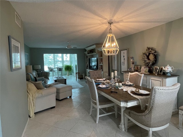 tiled dining room featuring ceiling fan and a textured ceiling