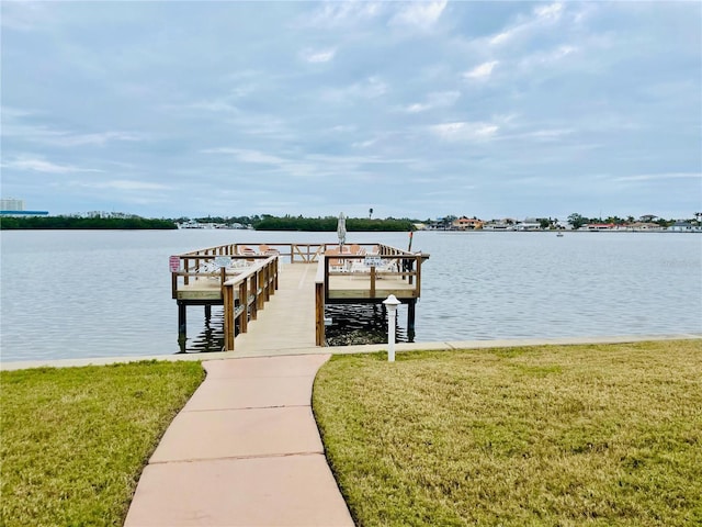 view of dock featuring a water view and a yard