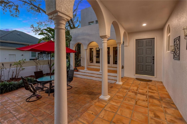 patio terrace at dusk featuring french doors