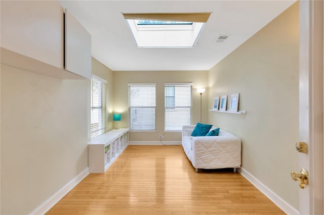 sitting room with a skylight and light wood-type flooring