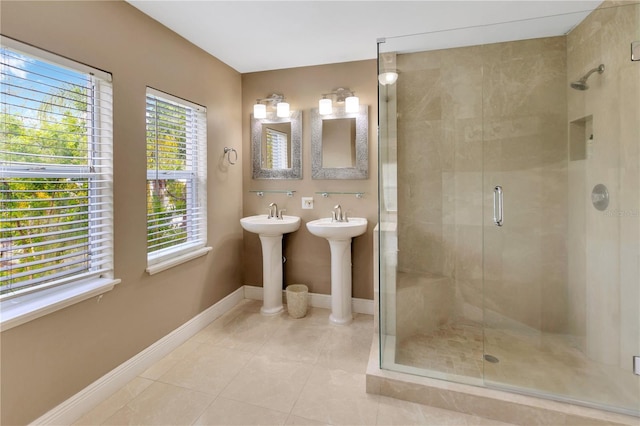 bathroom featuring walk in shower, tile patterned flooring, and dual sinks