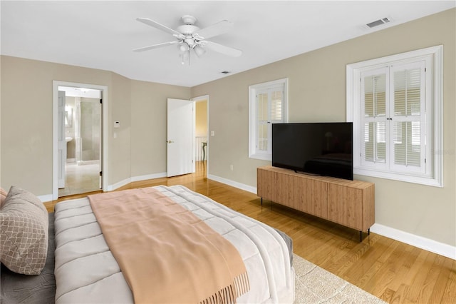 bedroom featuring ceiling fan, wood-type flooring, and ensuite bath