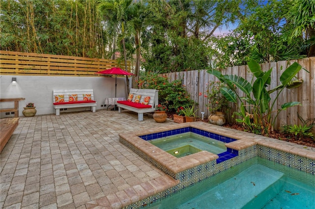 view of pool with a patio and an in ground hot tub