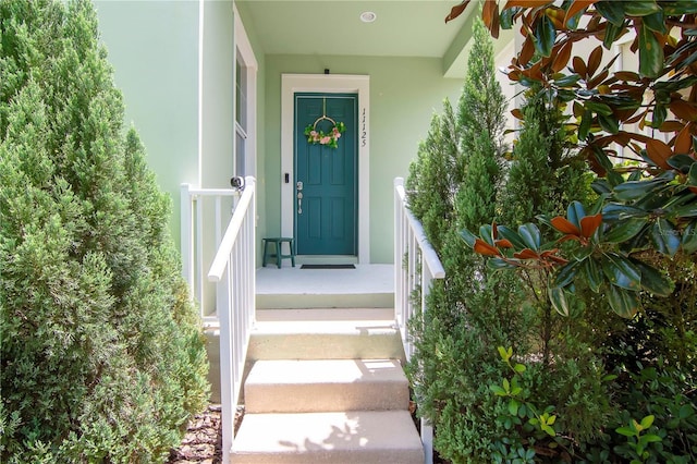 doorway to property featuring stucco siding