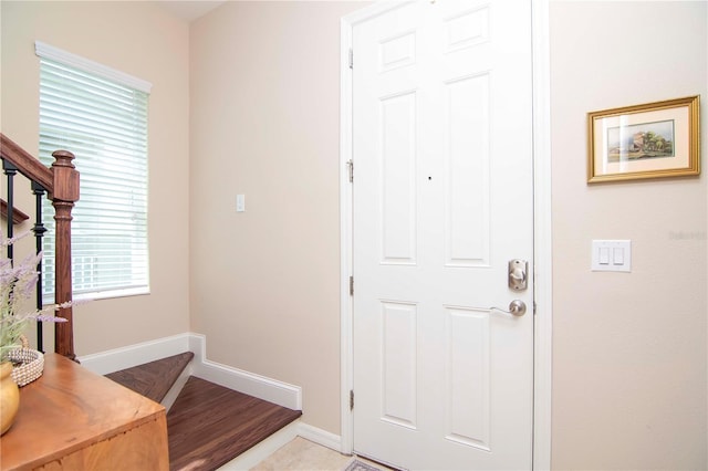 foyer entrance featuring baseboards and stairway