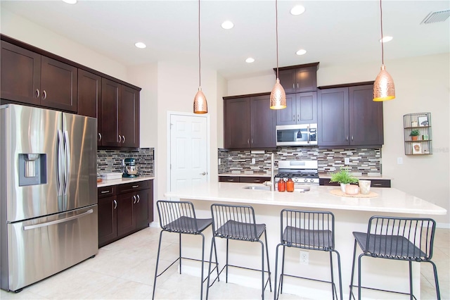 kitchen with visible vents, stainless steel appliances, dark brown cabinets, and light countertops