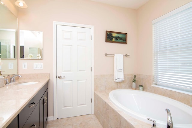 bathroom with a garden tub, tile patterned floors, and vanity