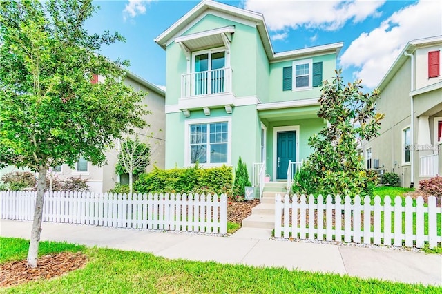 view of front of house with fence and stucco siding